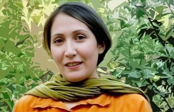 Bilde av en kvinne omringet av gr&oslash;nne blader. 