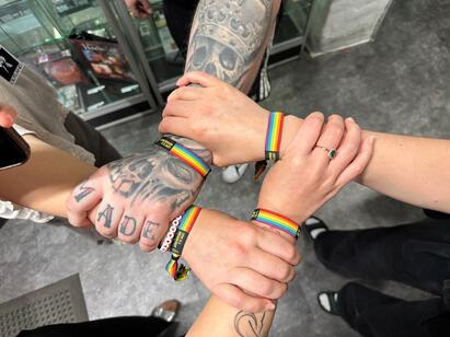 Bilde av fire hender med regnbuearmb&aring;nd