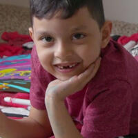 Carlos fra Mellom-Amerika ligger p&aring; gulvet og smiler til kameraet. 