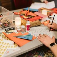 Hender som skriver brev med papir og tusjer p&aring; et bord, som del av en Amnesty-aksjon